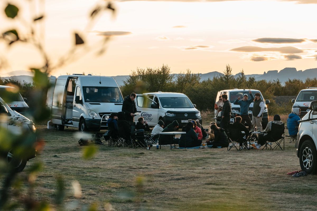 two people are sitting inside a campervan and smiling