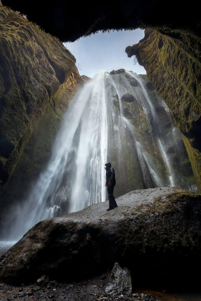 man standing in front of waterfall