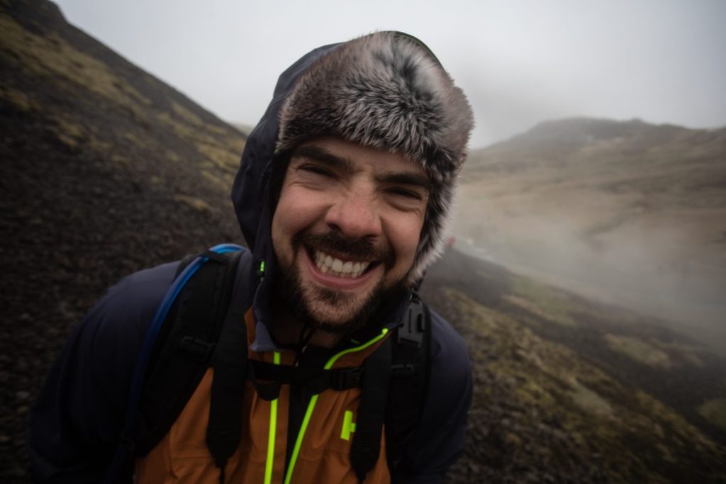 Man wearing a hat in front of steam