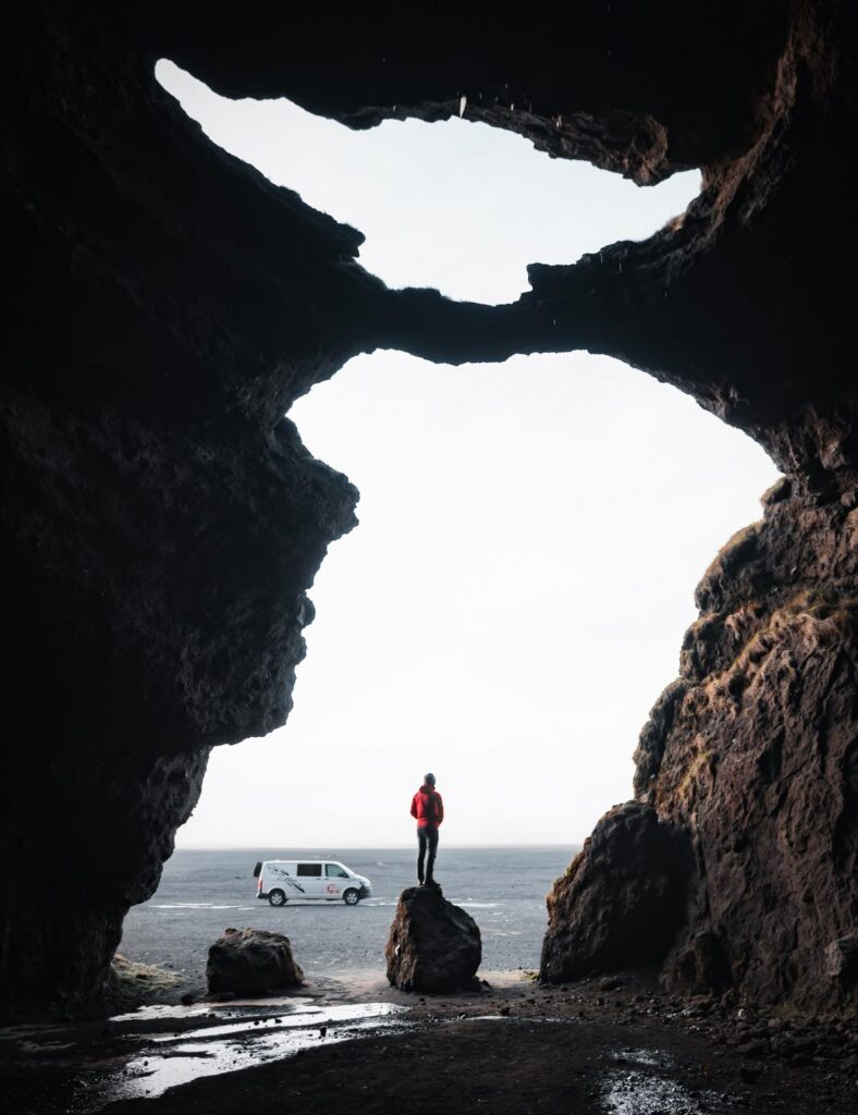 man standing on a rock and a van in the background