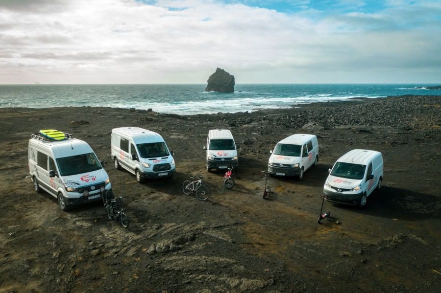Five campervans parked on the beach with a beautiful ocean view.
