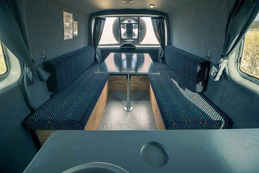 Interior of the campervan with table and beds.