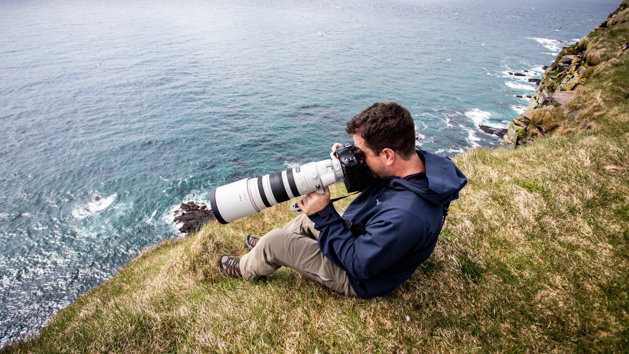 Man with large camera on a cliff