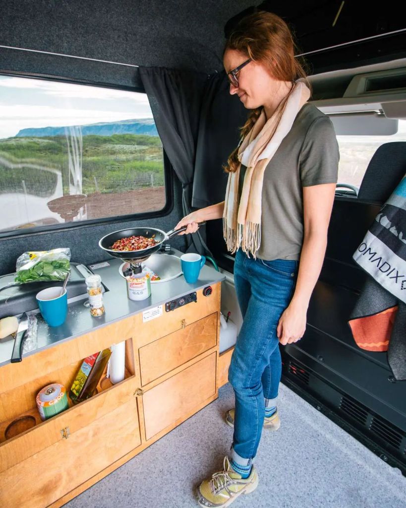 woman cooking in camper van