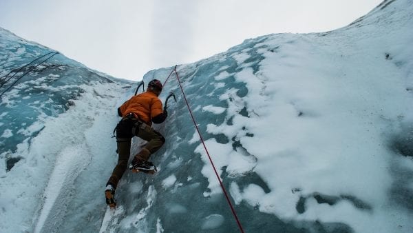 ice climbing a sheer face with a rope
