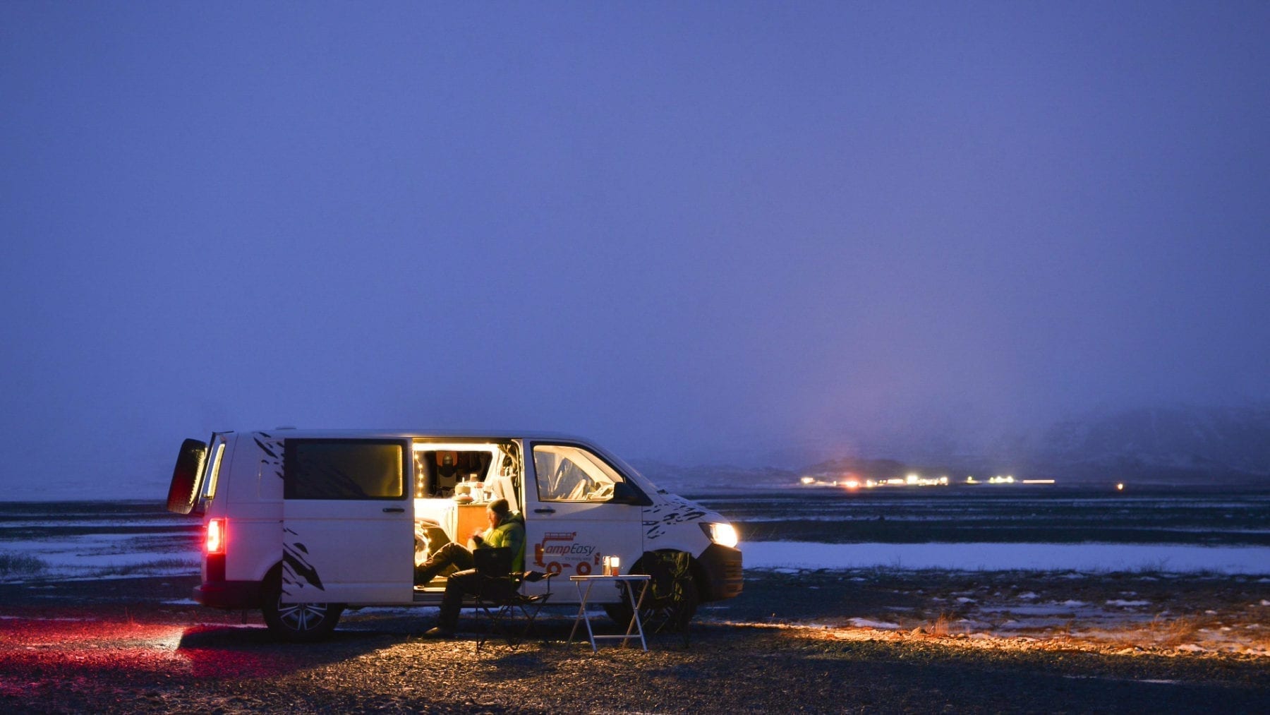 A man sitting in a camper van in the evening