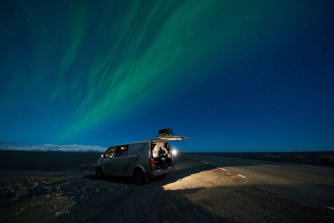 man taking photos of northern lights