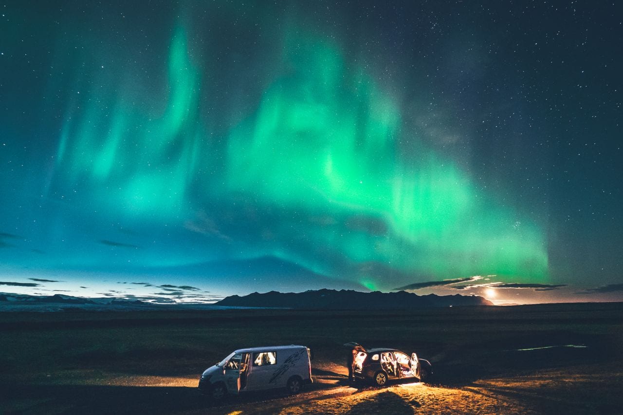 two cars under northern lights