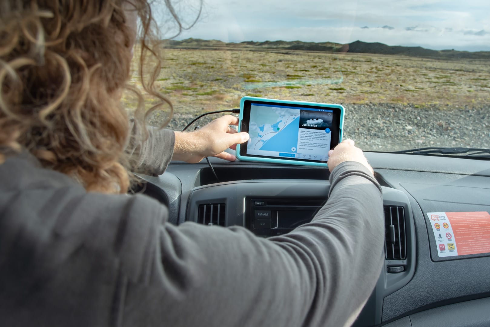 Person using a tablet in the Icelandic countryside