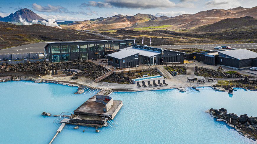 Geothermal bath complex with buildings and swimming pools. In the background there is a view on Icelandic nature