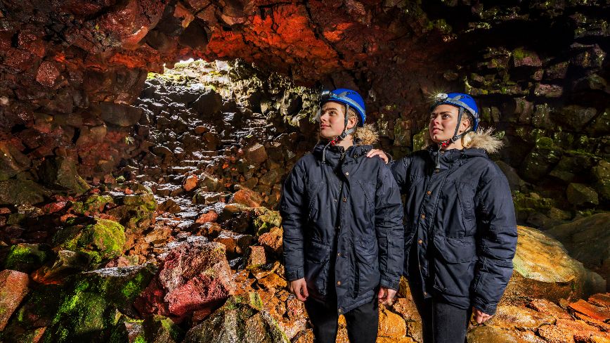 2 people watching a colorful lava chamber