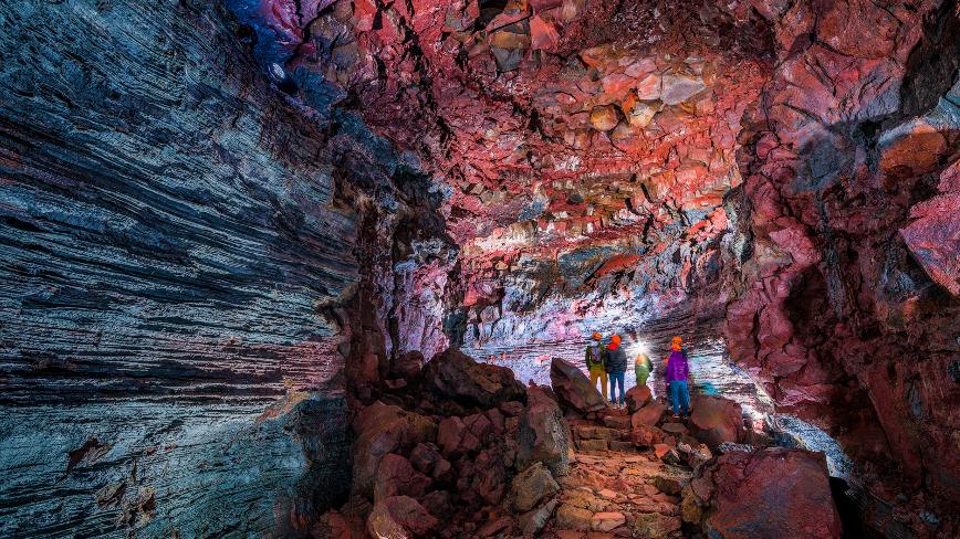 4 people watching a colorful cave