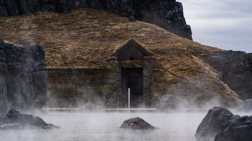 Steaming hot water with building inside rock in the background