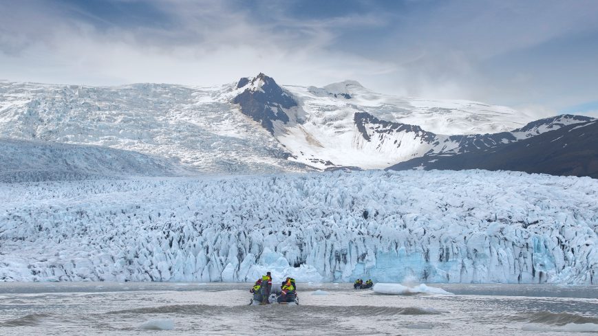 People in two boats watching glacier and mountains in Fjallsárlón Glacier Lagoon