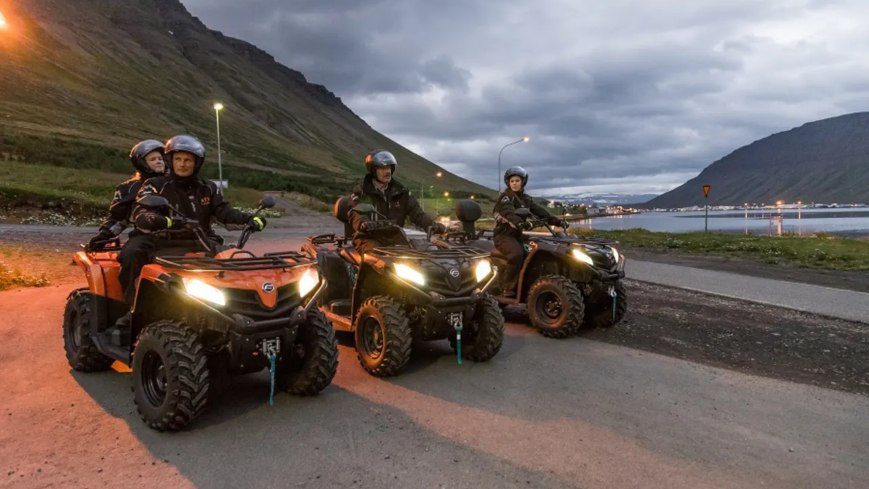 People at 3 ATV waiting for start their tour in Isafjordur. There are the mountains in the background