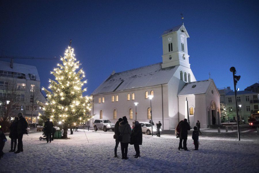 People standing around the Christmas Tree next to the church