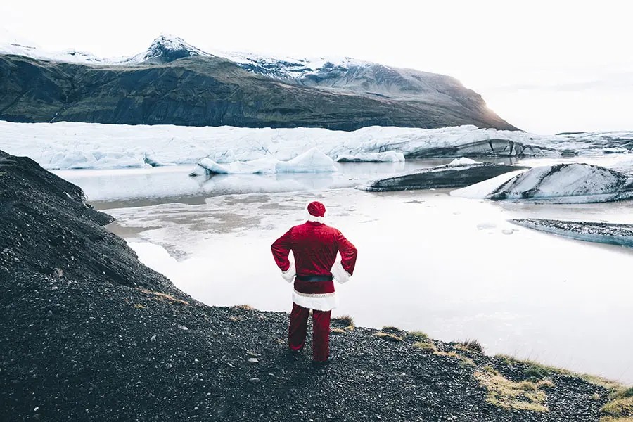 Traditional style authentic Santa Claus on his back looking at glaciers in Iceland