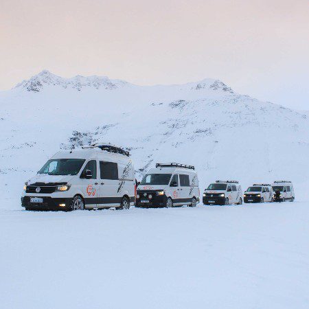 5 campers in the winter scenery with view on the mountains