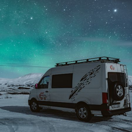 Campervan on the background of northern lights