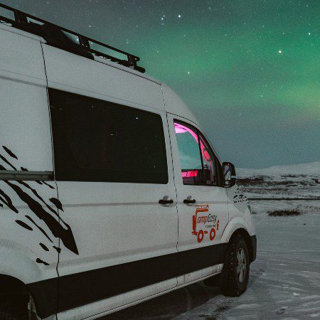View on the campervan . In the background there are northern lights