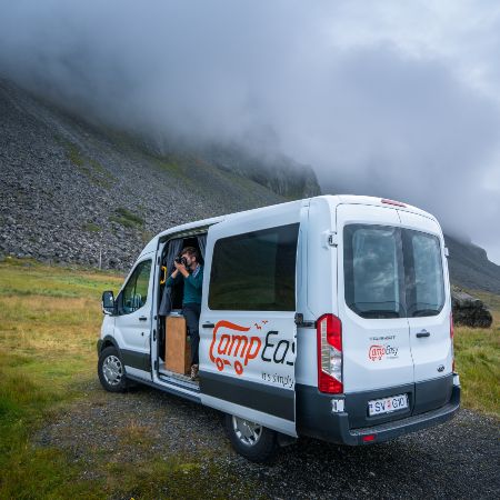 Man is taking a picture from open campervan