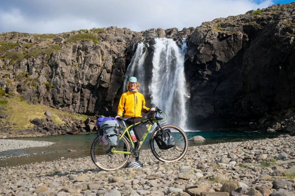 Man biker in front of a waterfall in Iceland.