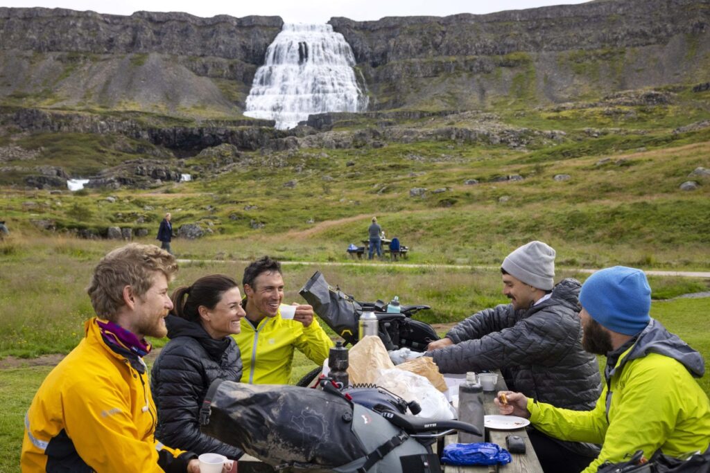 Group of people in the Westfjord nearby waterfall.