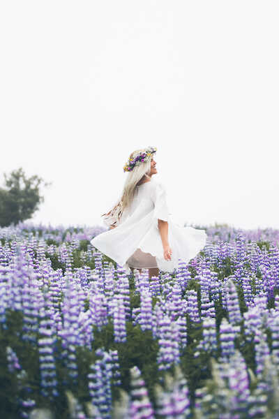 A woman is dancing in a lupin field