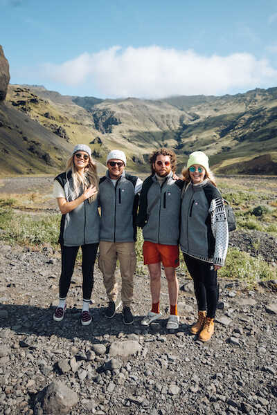 four people are standing against the background of the mountains