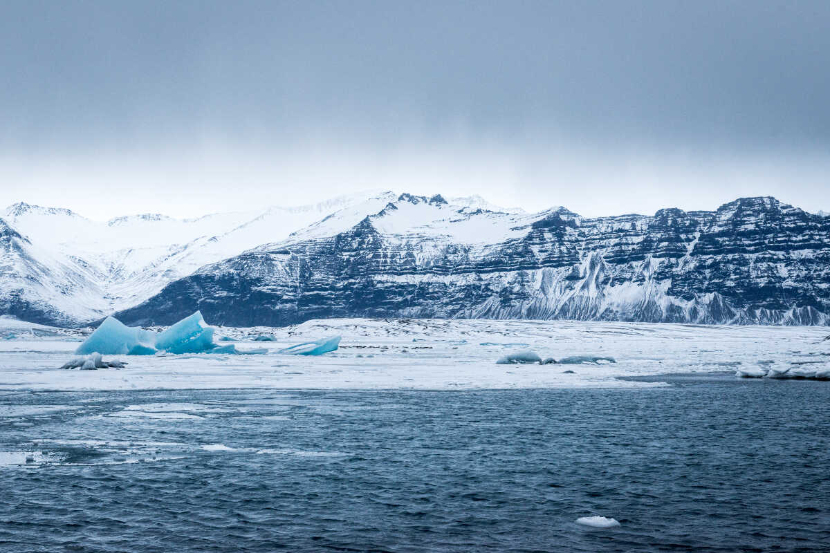 Glacier lagoon with floating icebergs and the mountain range in the background