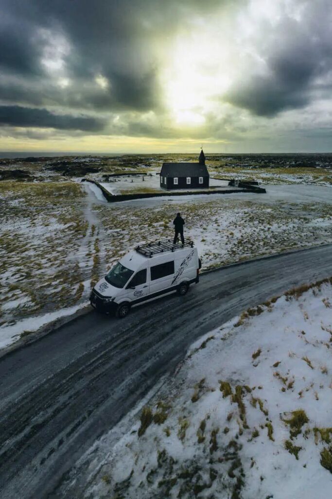 Parked campervan on the road and church