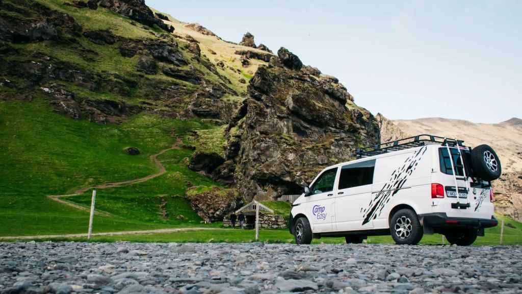 Campervan parked next to the Icelandic old house