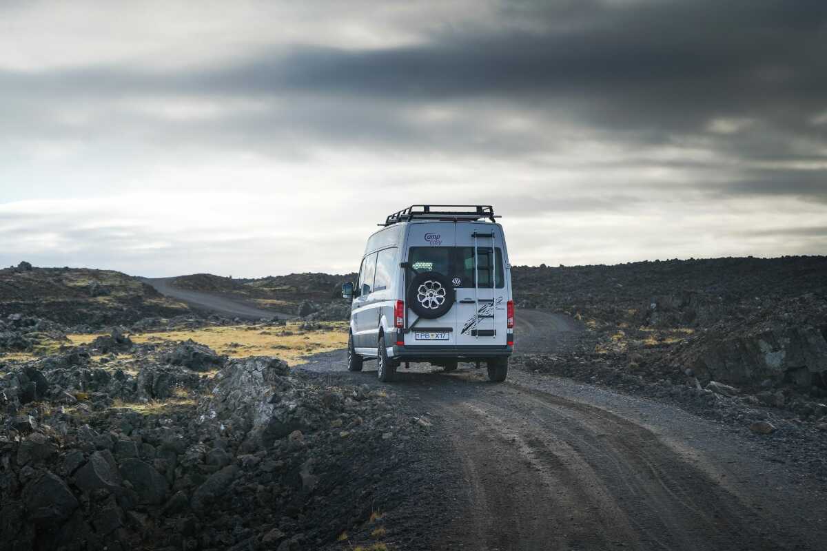 Campervan with the spare tire on the back parked on the gravel road