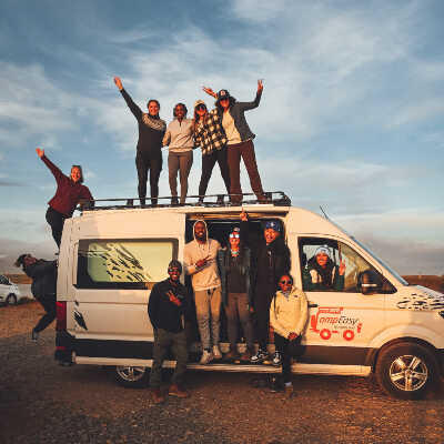 Group of people are on or in front of campervan