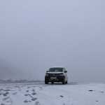 A CampEasy campervan stands isolated in a thick, snowy fog in Iceland, embodying a winter adventure in harsh yet stunning arctic conditions.