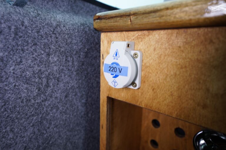 Photo of a 220V outlet located in the kitchenette in the middle of the campervan.