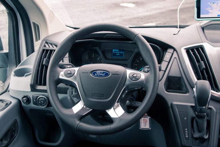 Interior view of a camping van showcasing the dashboard with controls and displays and the steering wheel.