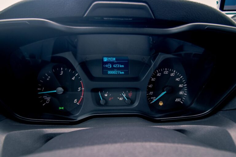 Close-up of a camping van dashboard with speedometer and multiple gauges indicating fuel, temperature, and engine status.
