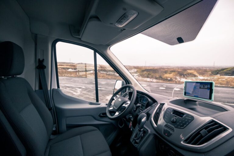 Interior view of a camping van showcasing the driver seat and the dashboard with controls and displays.
