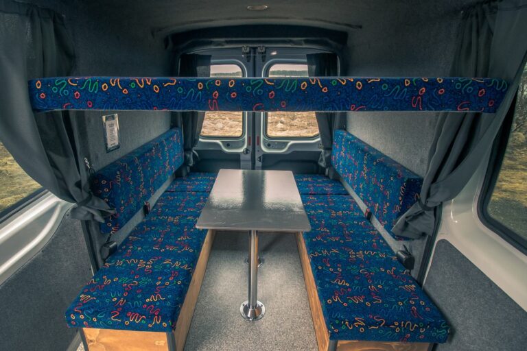 Interior view of a campervan with an assembled table and sitting area.