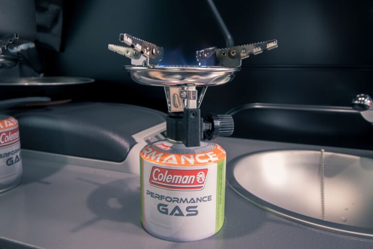 A gas can with a stove on top of it.