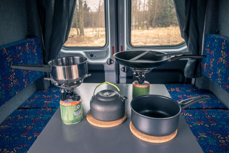 A table in a campervan in Iceland, displaying various pots and pans arranged on its surface