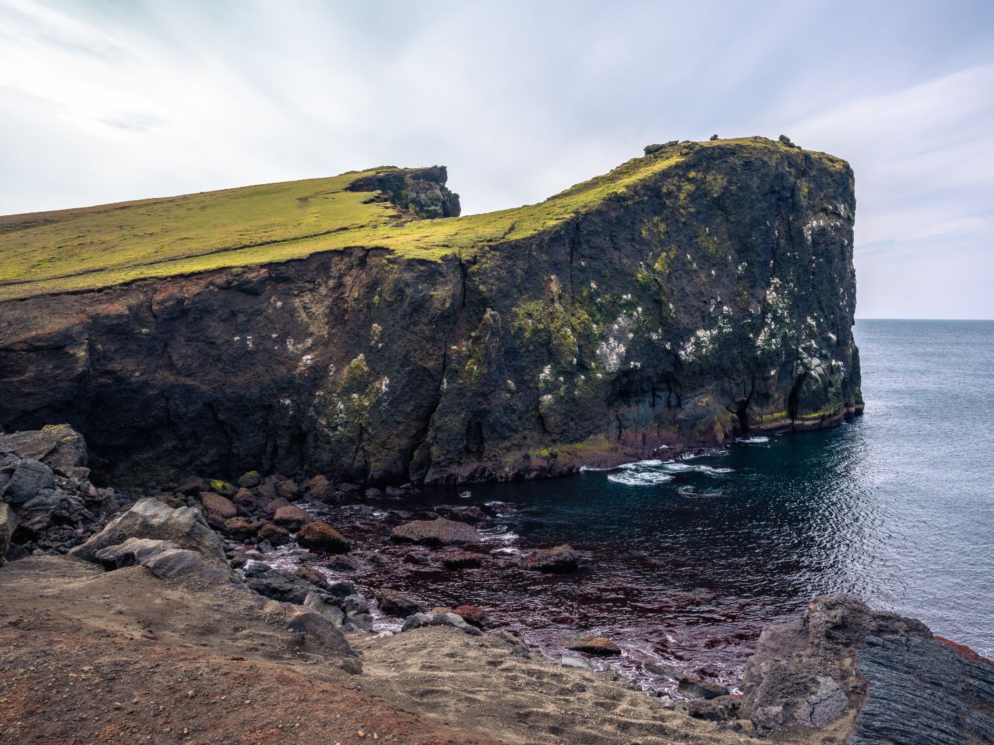 The powerful waves of the Atlantic crash against the jagged Valahnúkamöl cliffs beneath Mount Valahnúkur