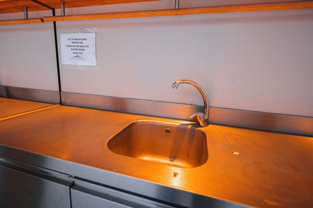 Stainless steel kitchen sink with a sleek faucet, under warm lighting.